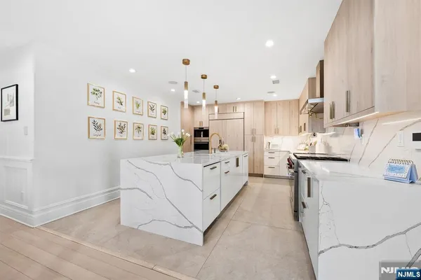 a kitchen with stainless steel appliances sink a stove and white cabinets