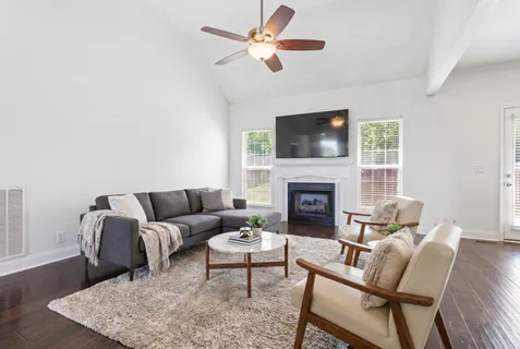 a living room with furniture a flat screen tv and a fireplace