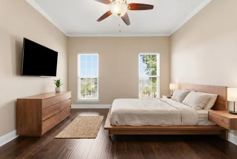 a bedroom with a large bed and a flat screen tv