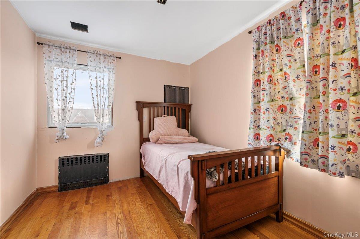 82-06 166th Street Queens, NY 11432 - Photo 15 of 25 Bedroom featuring radiator heating unit and wood finished floors