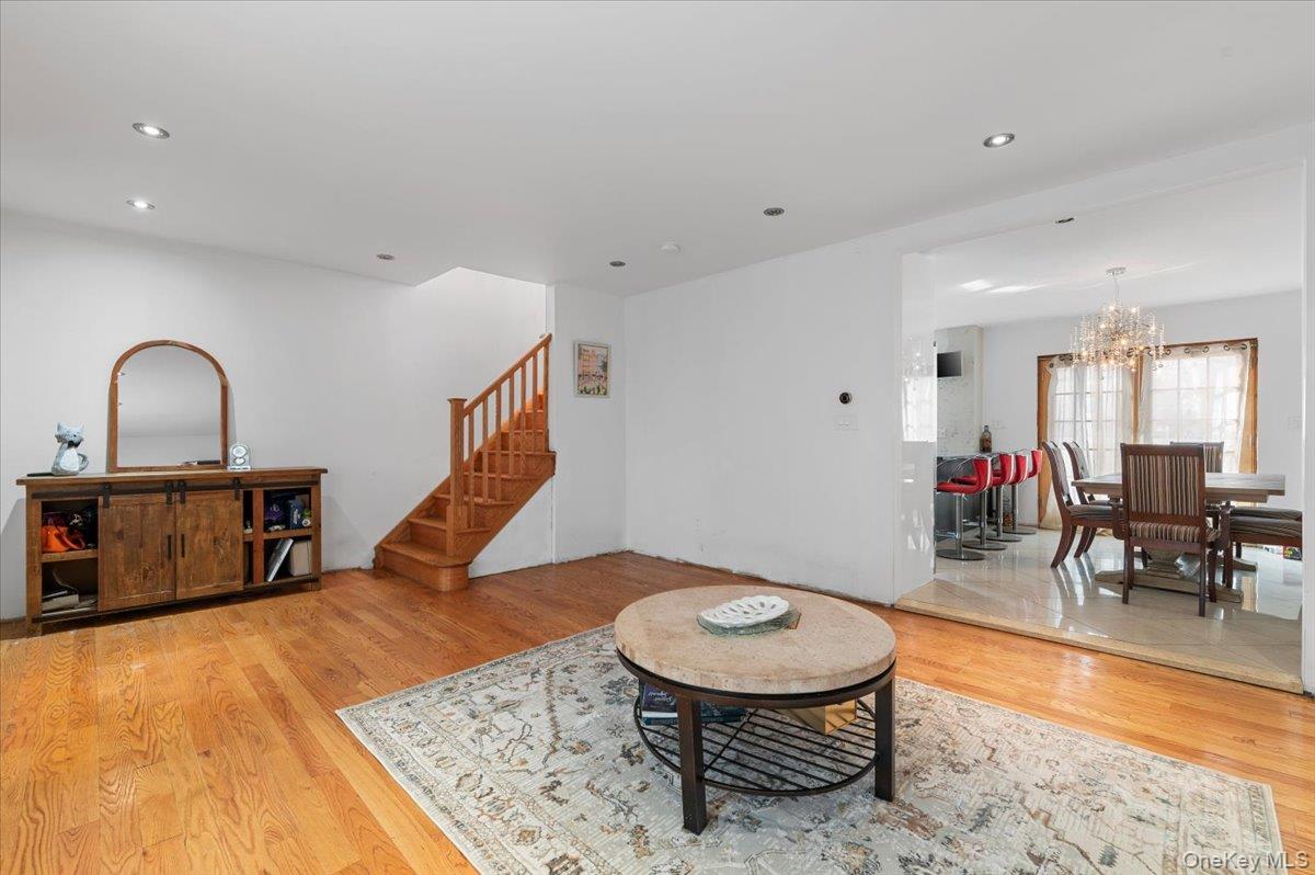 82-06 166th Street Queens, NY 11432 - Photo 2 of 25 Living room featuring light wood finished floors, stairs, a chandelier, and recessed lighting