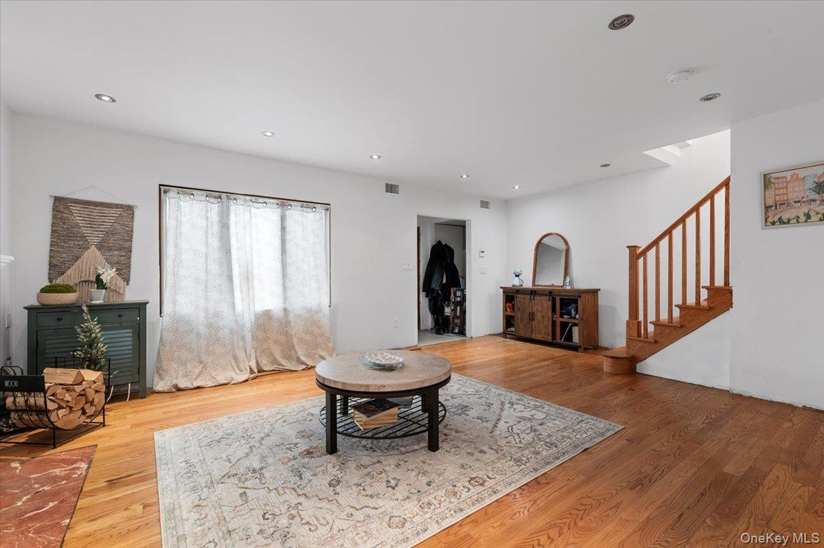 82-06 166th Street Queens, NY 11432 - Photo 3 of 25 Living area with light wood-style floors, stairway, and recessed lighting