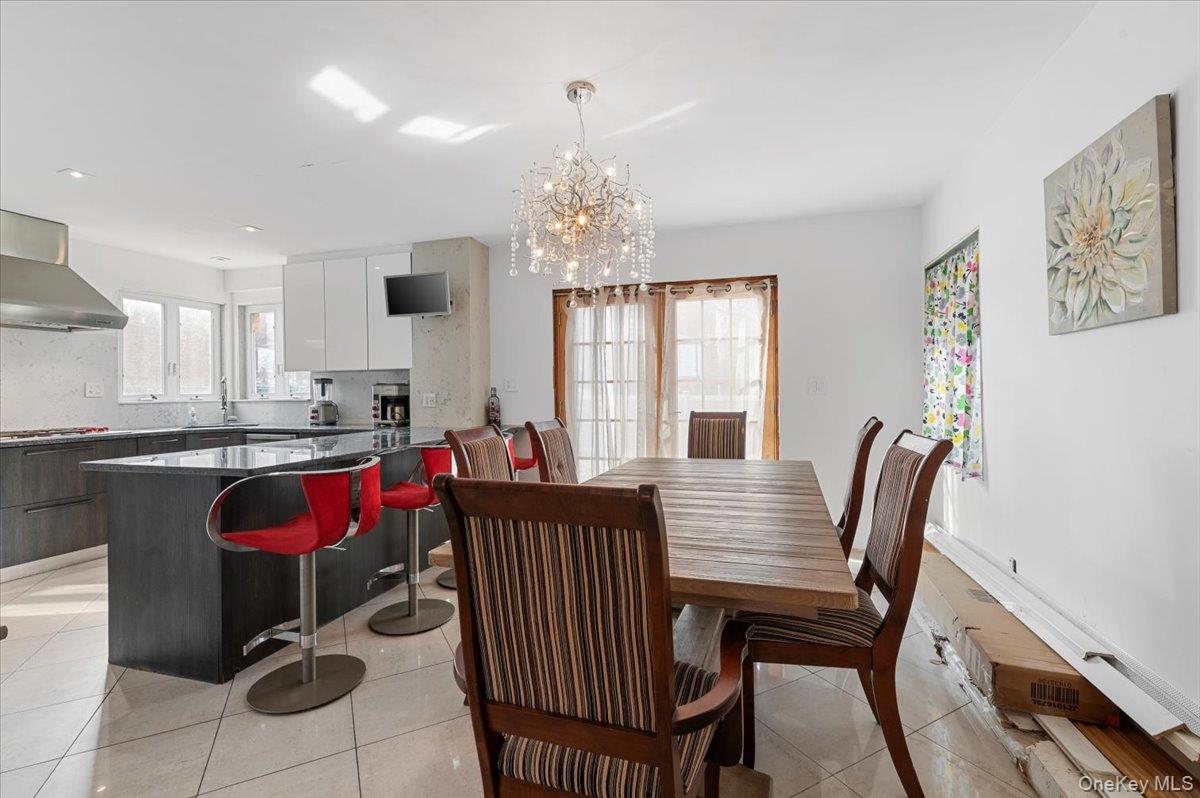 82-06 166th Street Queens, NY 11432 - Photo 5 of 25 Dining space featuring light tile patterned flooring and a chandelier