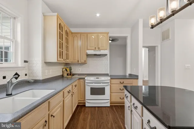 a kitchen with stainless steel appliances a sink stove and cabinets