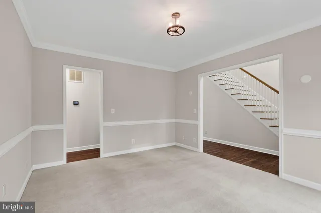 an empty room with wooden floor fireplace and windows