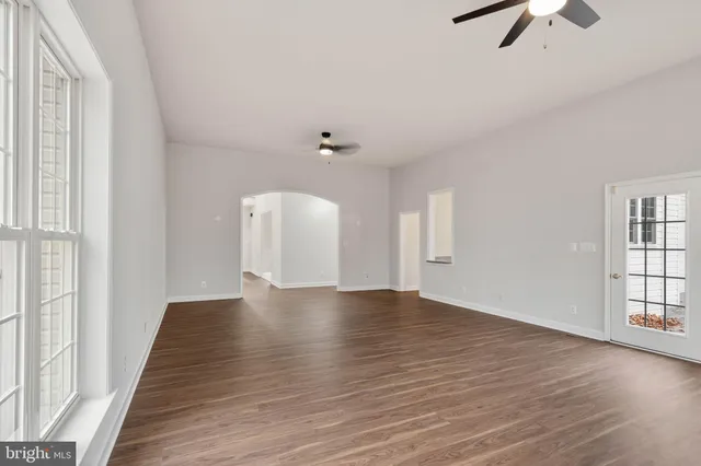 a kitchen with stainless steel appliances granite countertop a sink a stove a refrigerator and island with wooden floor