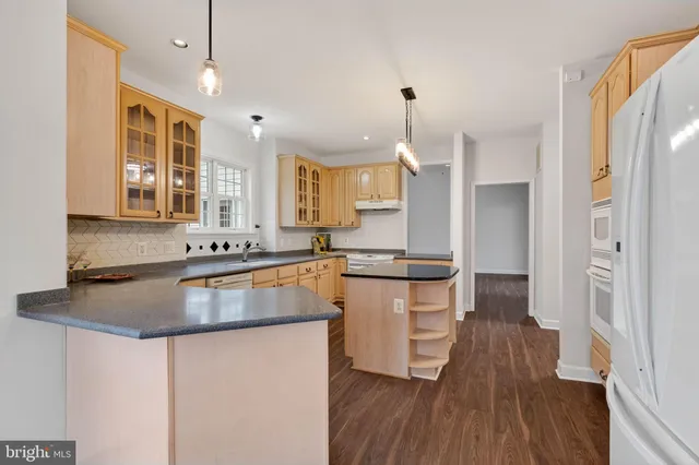 a kitchen with granite countertop a sink cabinets stainless steel appliances and a window