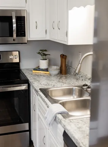 a kitchen with granite countertop a sink and a stove