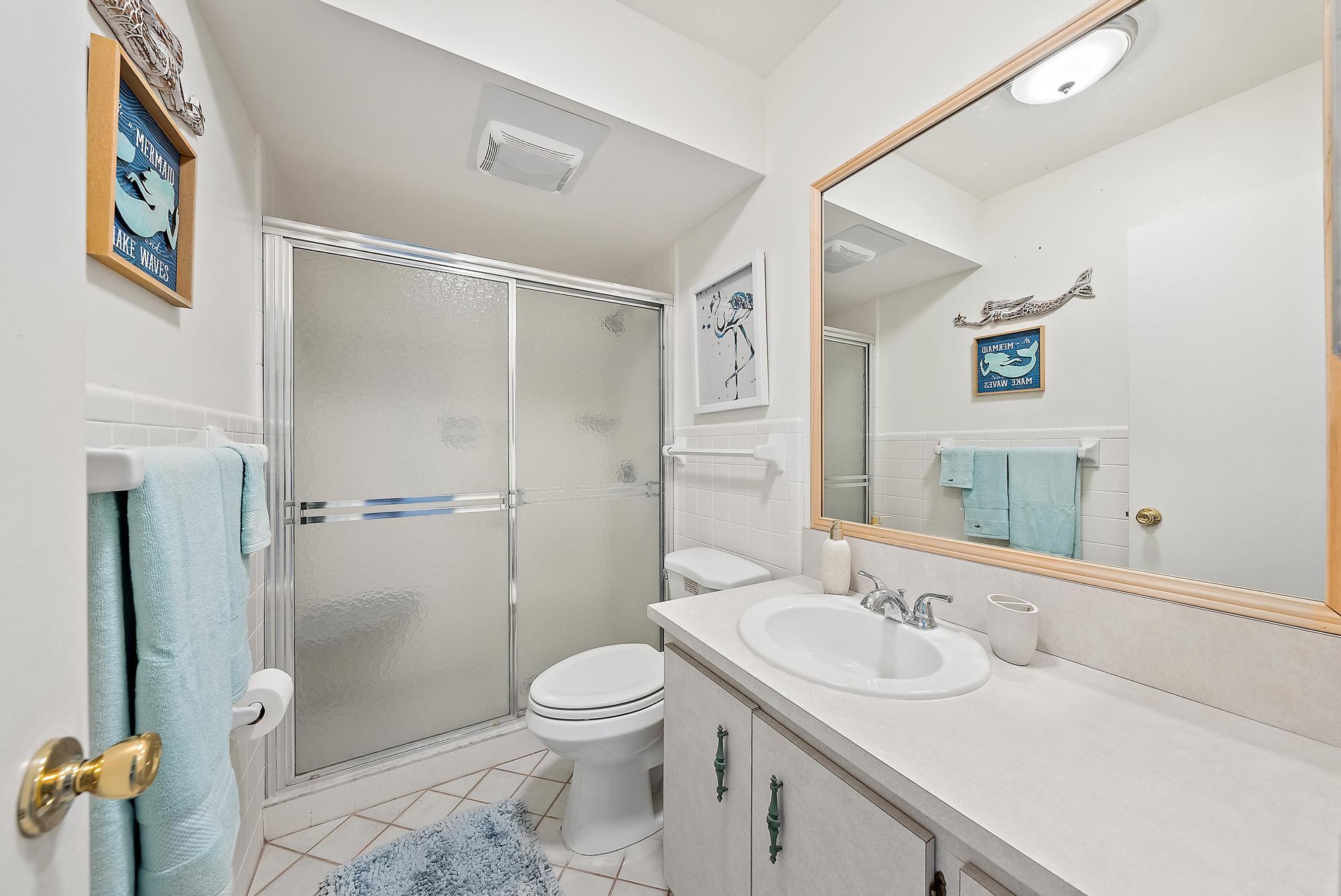 755 Saturn Street, Unit D205 Jupiter, FL 33477 - Photo 21 of 22 a bathroom with a sink toilet and shower