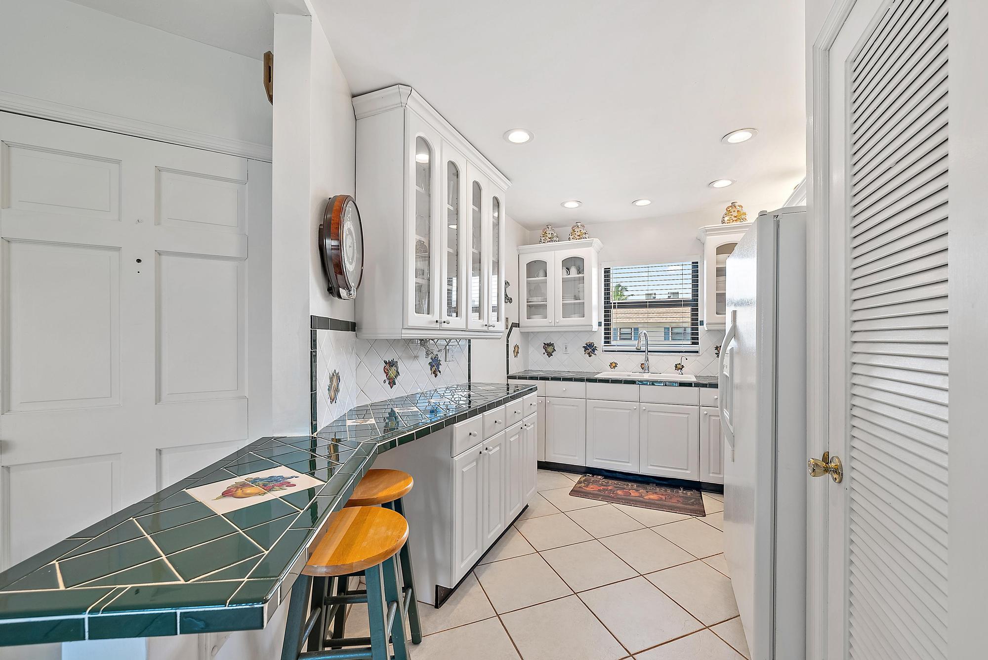 755 Saturn Street, Unit D205 Jupiter, FL 33477 - Photo 6 of 22 a kitchen with stainless steel appliances granite countertop a sink and cabinets