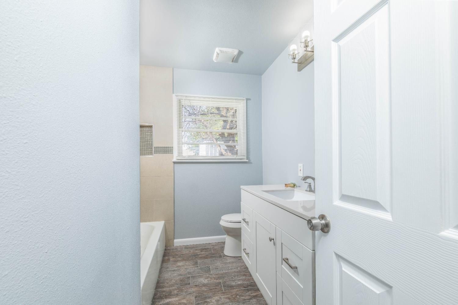 5116 47th Street Lubbock, TX 79414 - Photo 16 of 20 a bathroom with a sink toilet and a mirror
