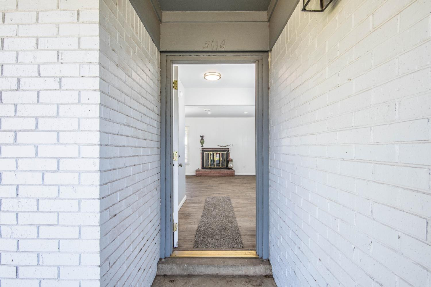 5116 47th Street Lubbock, TX 79414 - Photo 2 of 20 a view of a hallway with wooden floor and a bathroom