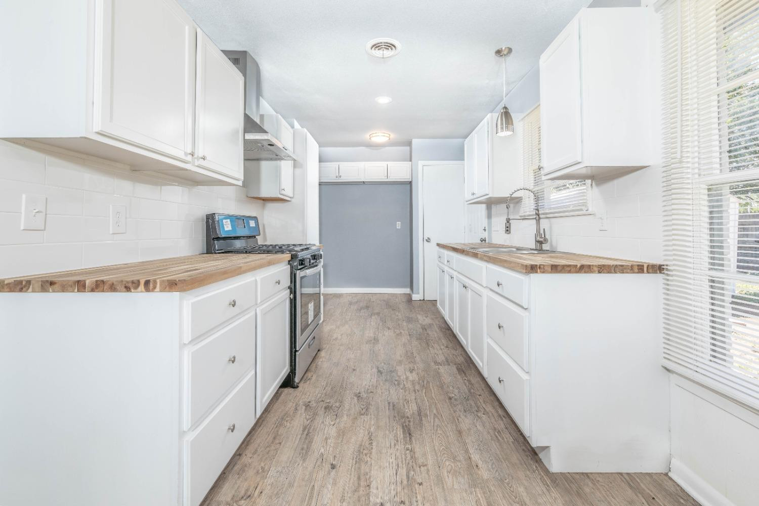 5116 47th Street Lubbock, TX 79414 - Photo 8 of 20 a kitchen with granite countertop white cabinets and white appliances