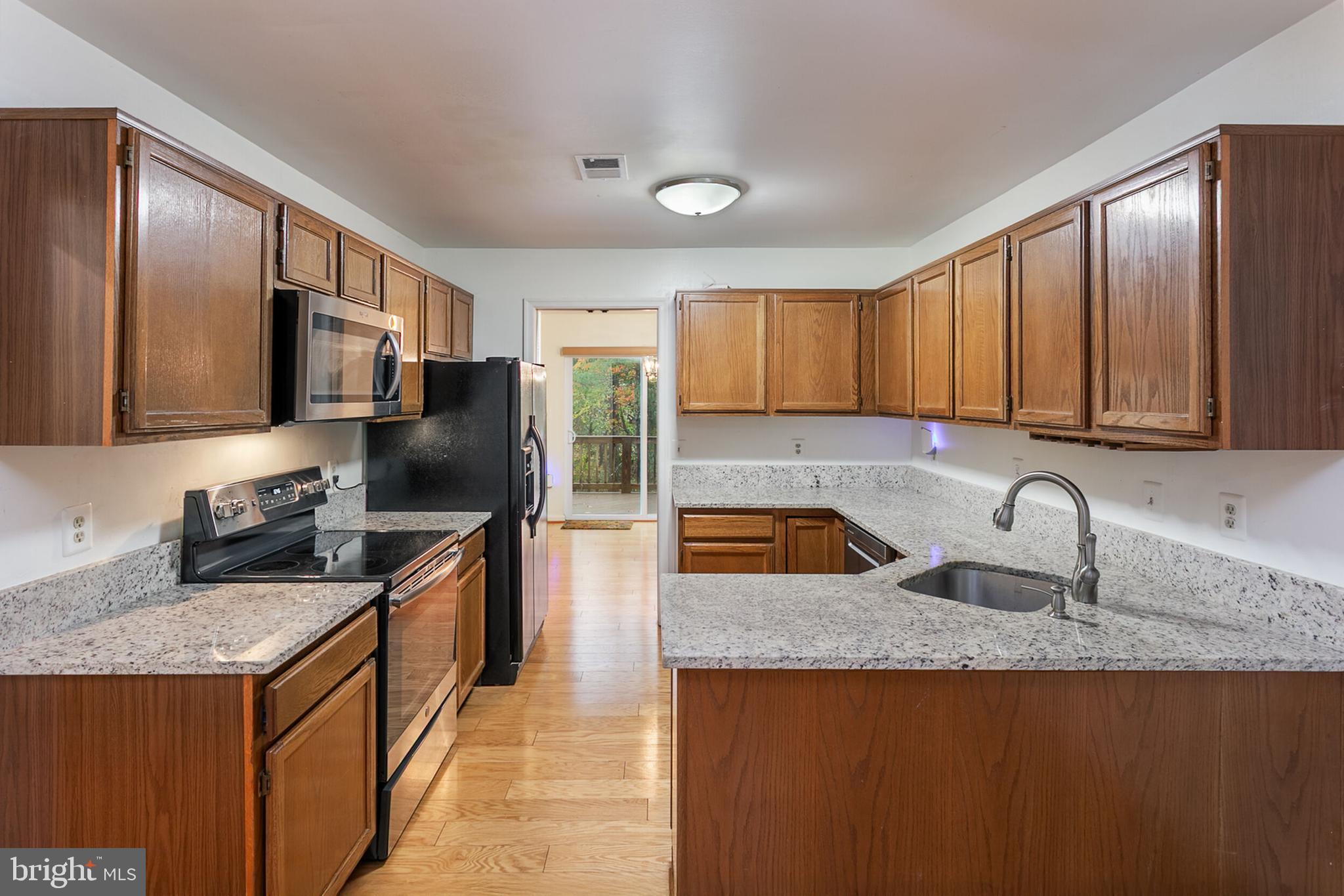 14 Tivoli Lake Court Silver Spring, MD 20906 - Photo 7 of 20 a kitchen with stainless steel appliances granite countertop a sink stove microwave and refrigerator