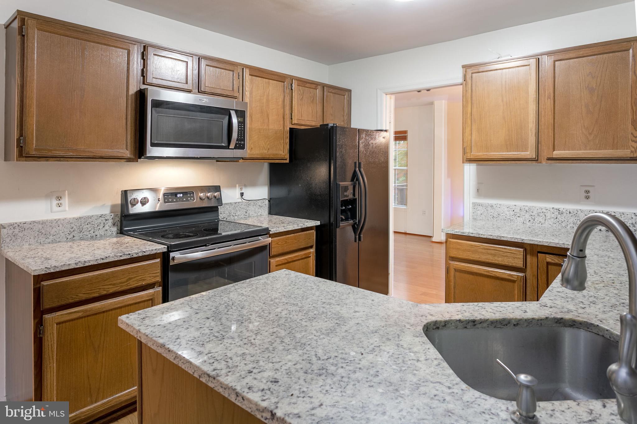 14 Tivoli Lake Court Silver Spring, MD 20906 - Photo 8 of 20 a kitchen with stainless steel appliances granite countertop a sink stove and refrigerator