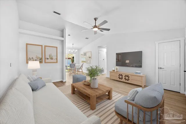 a living room with furniture a flat screen tv and a window