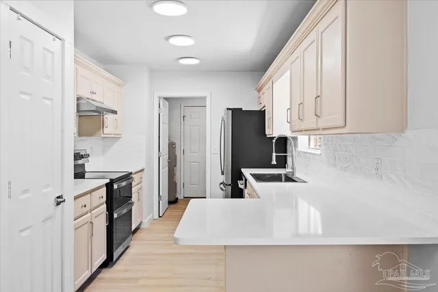 a kitchen with refrigerator and cabinets