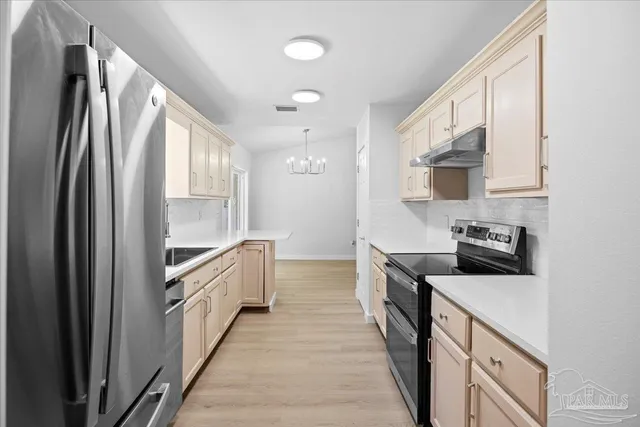 a kitchen with stainless steel appliances granite countertop a refrigerator a stove top oven a sink and dishwasher