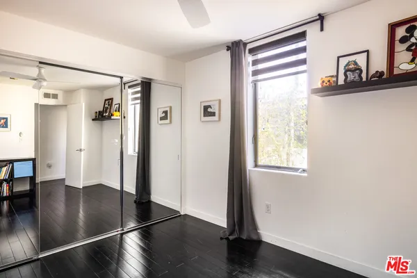 a view of a hallway with wooden floor and a living room