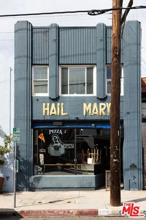 a store with outdoor seating and a potted plant