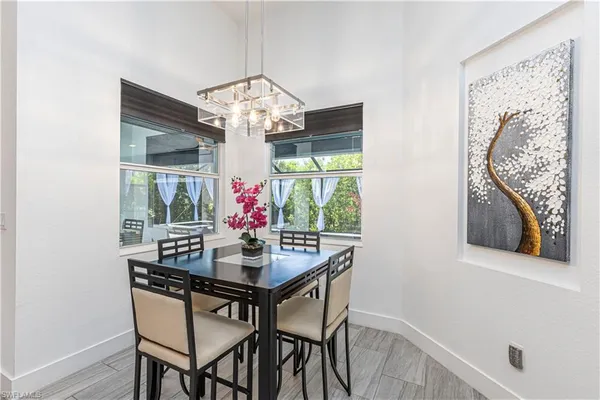 a view of a dining room with furniture a chandelier and wooden floor