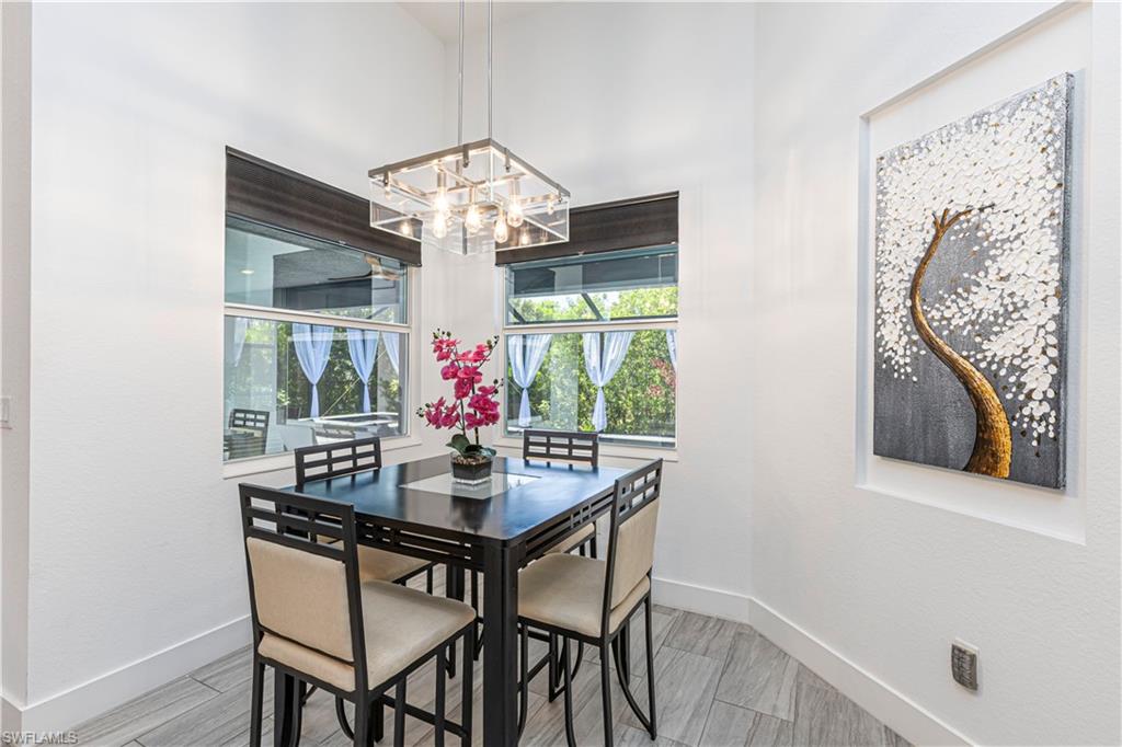 27180 Williams Road Bonita Springs, FL 34135 - Photo 12 of 42 a view of a dining room with furniture a chandelier and wooden floor
