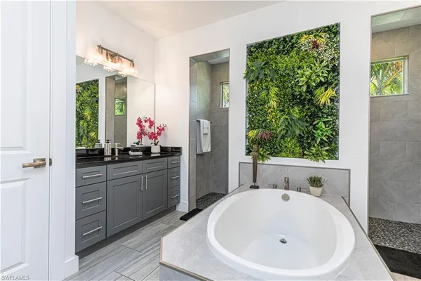 a bathroom with a bathtub sink and mirror