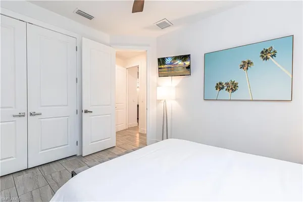 a bedroom with a bed and a painting on the wall