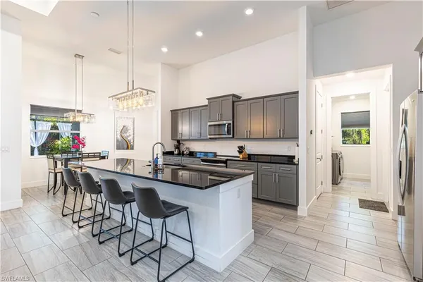 a kitchen with stainless steel appliances granite countertop a stove top oven a sink dishwasher a dining table and chairs