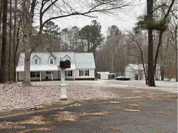 a front view of a house with a yard covered in snow