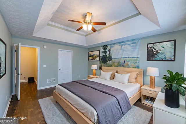 a spacious bedroom with a bed and a flat screen tv