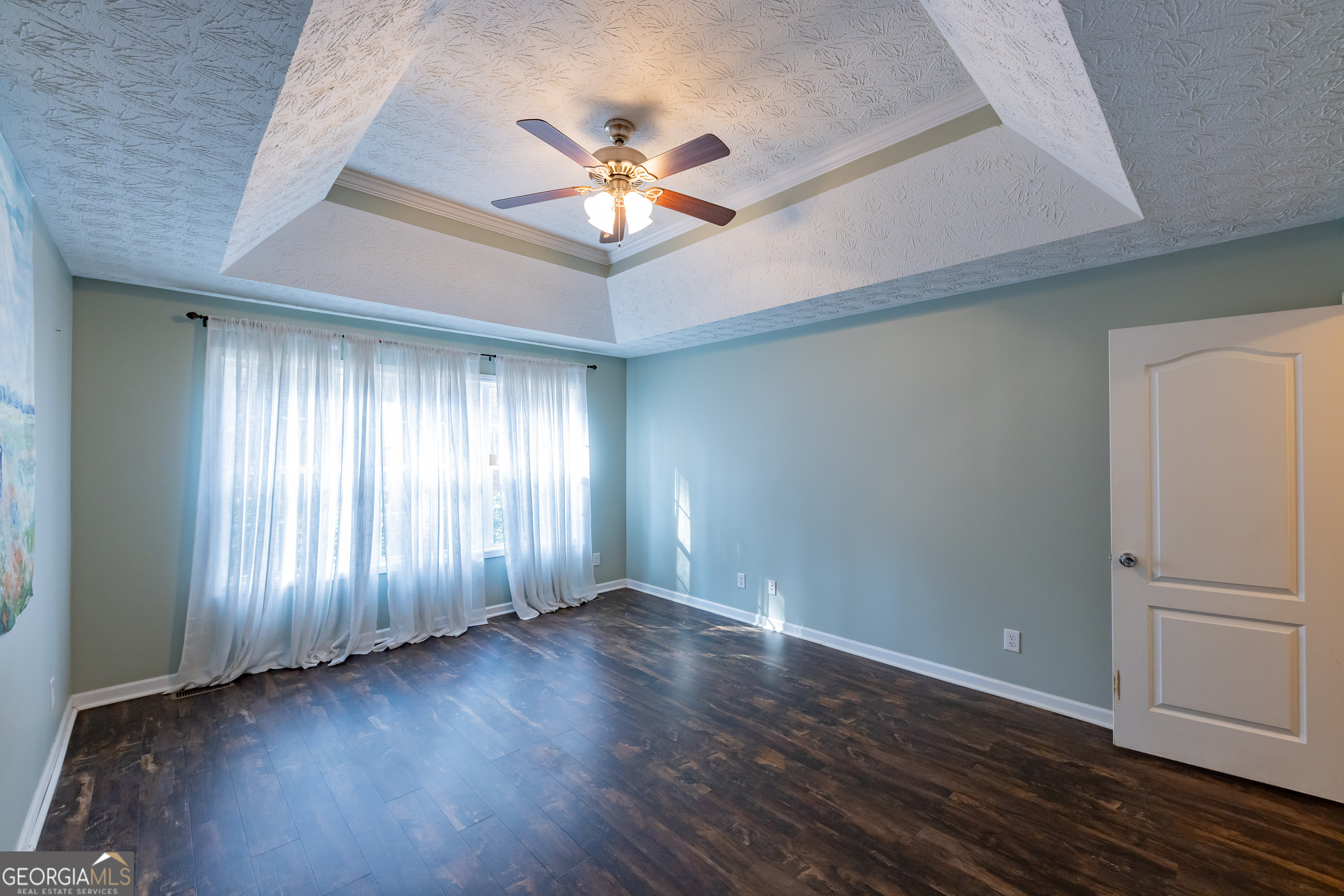 123 Rabbit Run Drive Meansville, GA 30256 - Photo 20 of 101 an empty room with wooden floor chandelier fan and windows