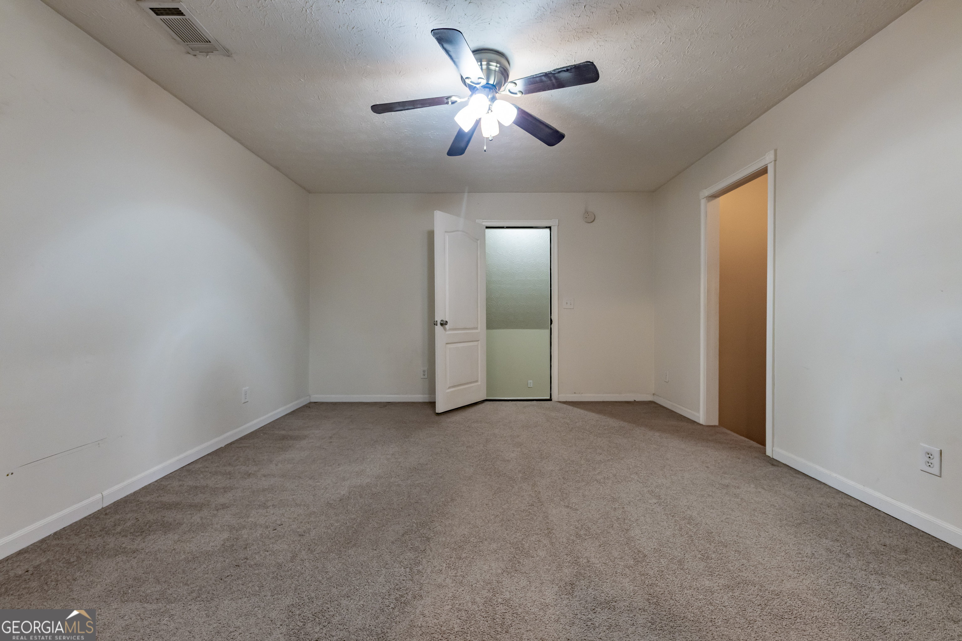 123 Rabbit Run Drive Meansville, GA 30256 - Photo 37 of 101 an empty room with chandelier fan and windows