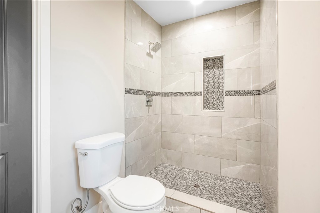 8466 Quartz Avenue Winnetka, CA 91306 - Photo 13 of 16 a white toilet sitting next to a bath tub
