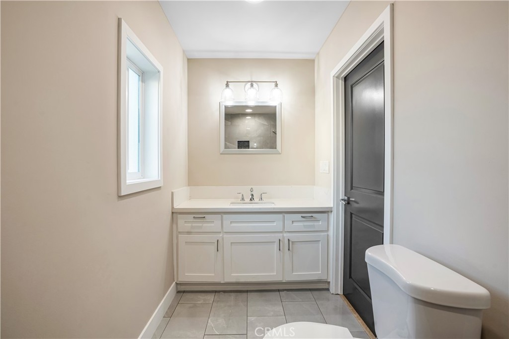8466 Quartz Avenue Winnetka, CA 91306 - Photo 14 of 16 a bathroom with a toilet sink and mirror