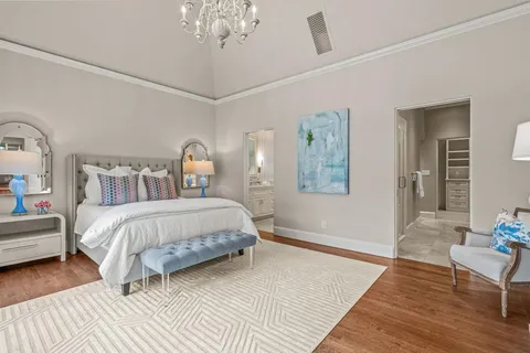 a bedroom with a bed wooden floor and window