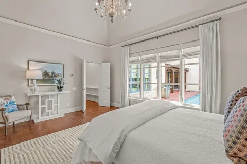 a bedroom with a large bed and a chandelier