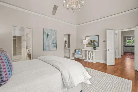 a bedroom with a large bed a chandelier and closet