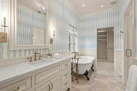 a spacious bathroom with a double vanity sink mirror and a bathtub