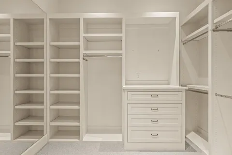 a view of walk in closet with empty racks