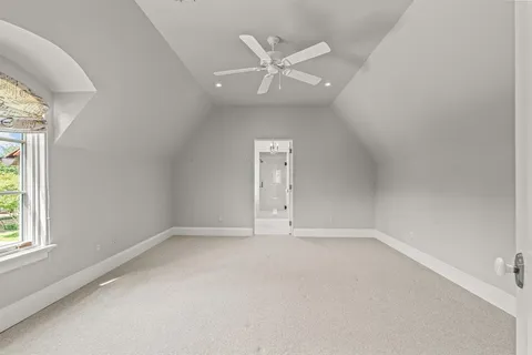 an empty room with a ceiling fan and window