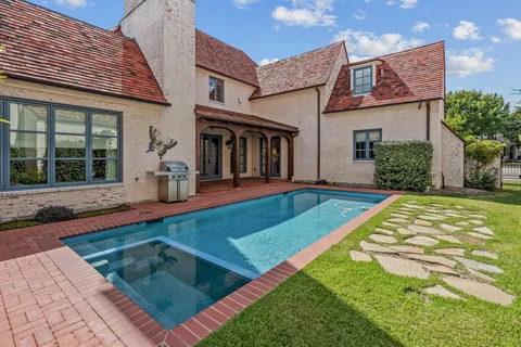 a view of a house with swimming pool and a yard