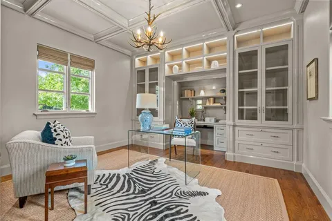 a living room with furniture a chandelier and wooden floor