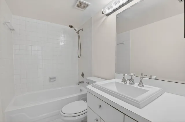 a bathroom with a sink toilet vanity and shower