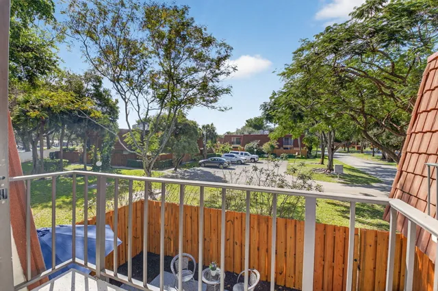 a view of a deck with a large trees and wooden fence