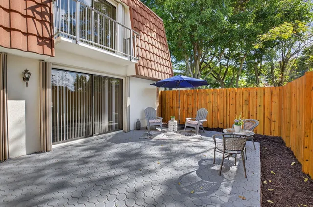 a view of a patio with a table and chairs under an umbrella
