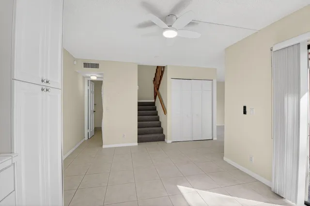 an empty room with a ceiling fan and entryway