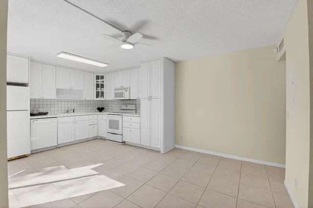 a kitchen with white cabinets and white appliances