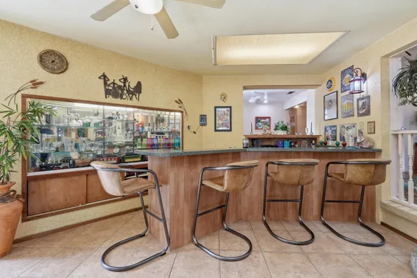 a kitchen with stainless steel appliances granite countertop a refrigerator a stove a sink and white cabinets with wooden floor