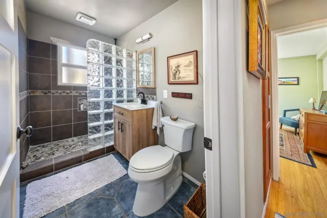 a white toilet sitting next to a bathroom sink and a shower